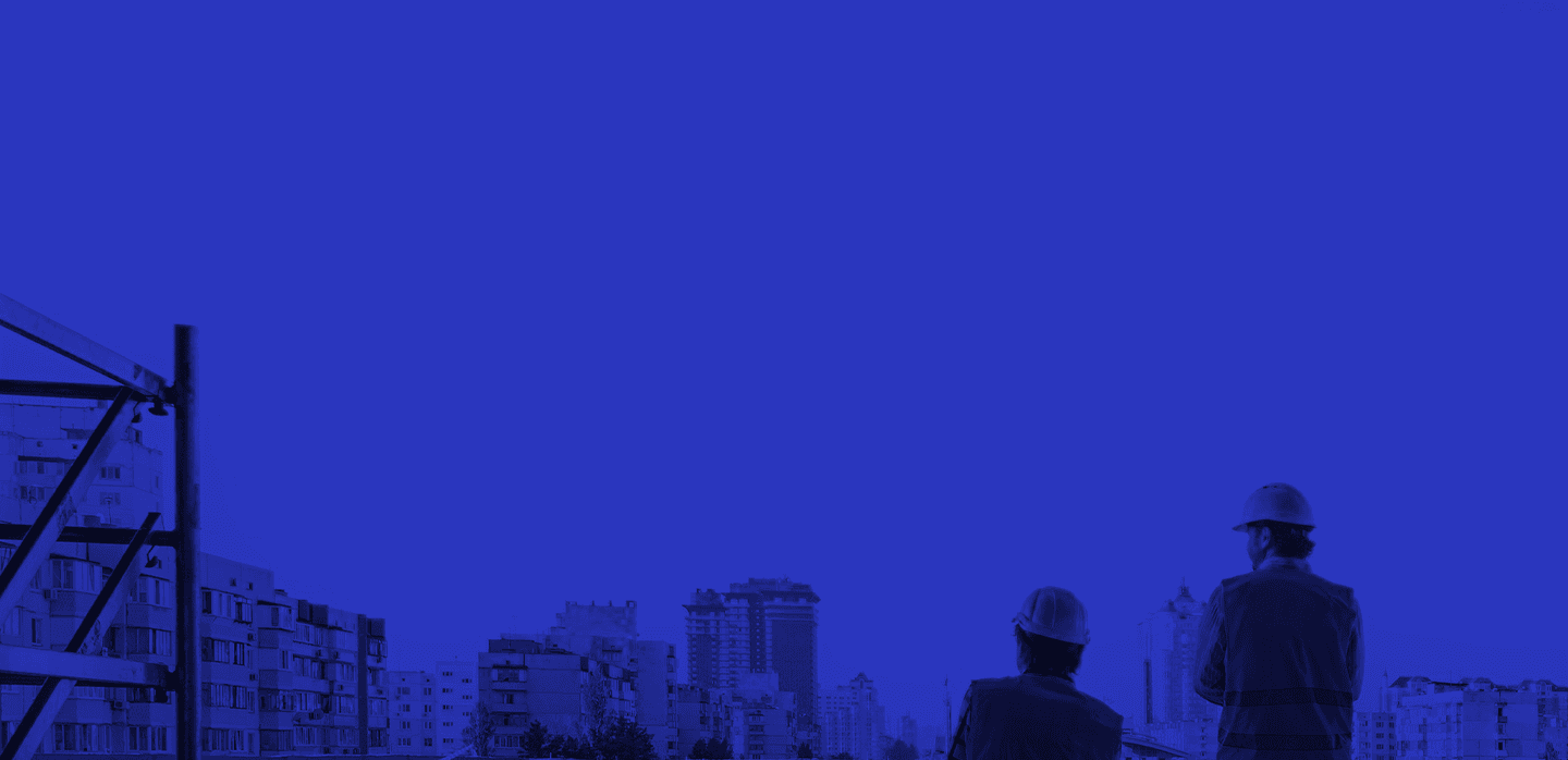 image of construction workers looking out towards cityscape from the roof of a building under construction